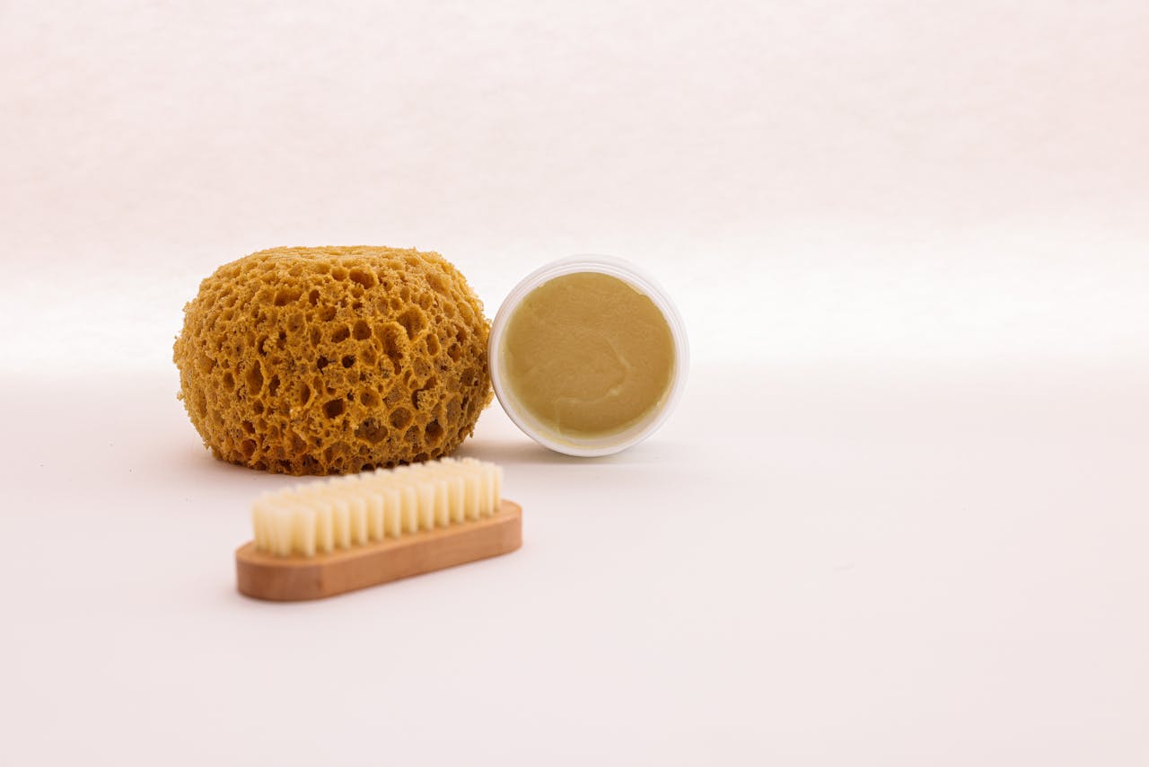 A Brush, a Sponge and a Cream in a Container