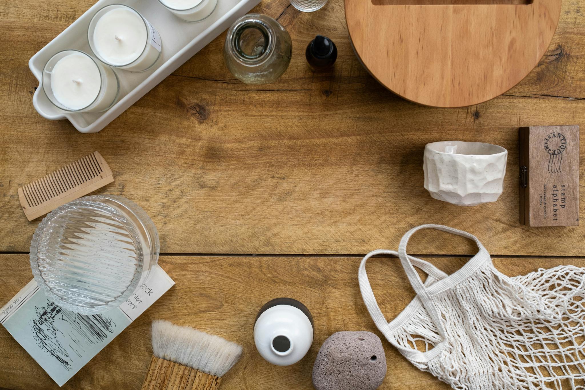 A flat lay of eco-friendly, zero waste items on a wooden surface, featuring candles.